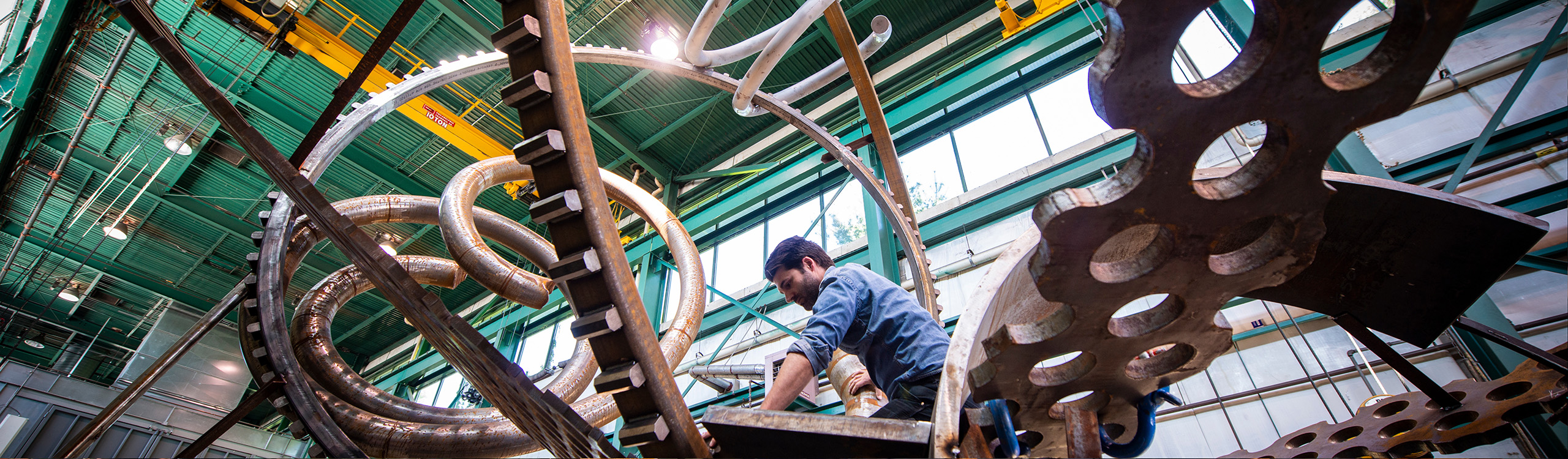 an artist works on a big metal sculpture