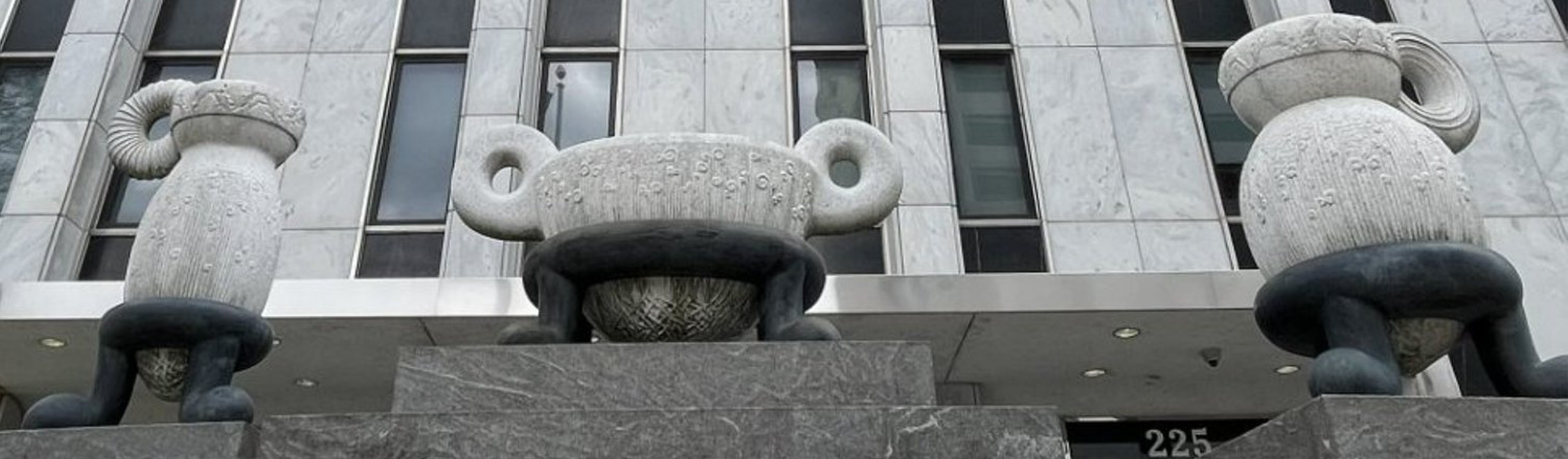 three large sculptures in front of a building entrance