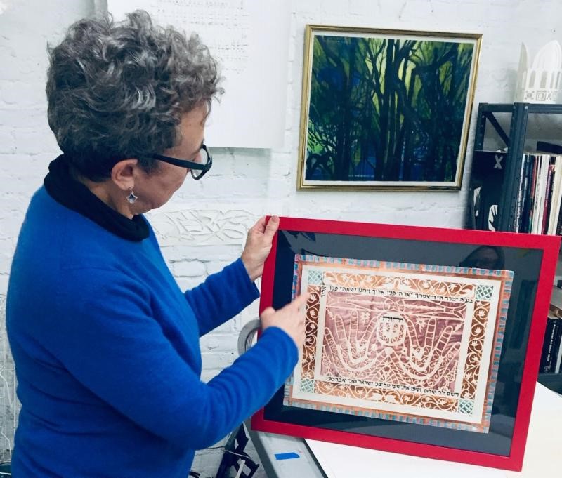 Deborah pointing out the candy wrapper detailing in an early papercut of hers; made as a study and example of a N. African papercut from 18th or 19th century. Typical of the Islamic style adopted by Jews living there.